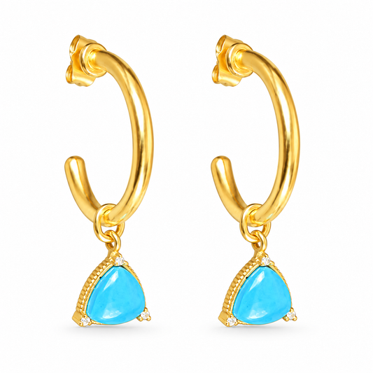A pair of gold huggie hoop earrings with dangling turquoise blue triangular gemstones, shown on a plain white background.

